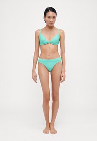 Bikini de culoare aquamarine cu un top triangular și un fund de tip low-rise. Materialul texturat are linii subtile, creând un aspect elegant.