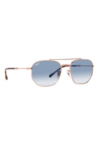Occhiali da sole Ray-Ban con forma esagonale, montatura in metallo color oro rosa e lenti gradientate blu. Dotati di para-naso trasparenti e punte delle aste in tessuto tartarugato.
