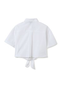 Witte crop-top met korte mouwen, omklapbare kraag en strikdetail op de rug. Gemaakt van lichte stof met een gladde textuur.