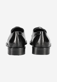 Schwarze Lederschuhe mit einer glatten, glänzenden Textur und einer runden Form; niedrige Absatzhöhe und zwei runde Ausschnitte auf der Rückseite.