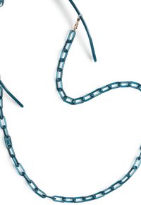 Vihreä aurinkolasiketju, joka on valmistettu linkitystä muovista, jossa on suurempia suorakaiteen muotoisia linkkejä ja ohuempia hihnoja kultaisilla varusteilla.