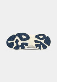 Suela de zapatilla de goma con un patrón texturizado. Predominantemente azul oscuro con acentos crema y una sección central lisa y flexible.
