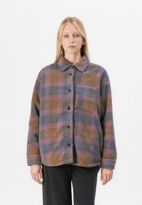 Giacca camicia in pile con motivo a quadri multicolori nei toni di marrone, blu e rosa. Presenta una chiusura a bottoni e un colletto.