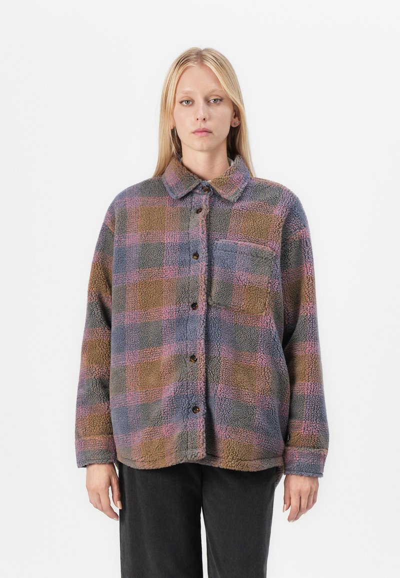 Giacca camicia in pile con motivo a quadri multicolori nei toni di marrone, blu e rosa. Presenta una chiusura a bottoni e un colletto.