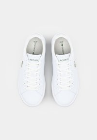 Adidași albi cu un superior din piele netedă, design cu șireturi, accent de logo verde și vârf rotund. Include branding pe limbă.