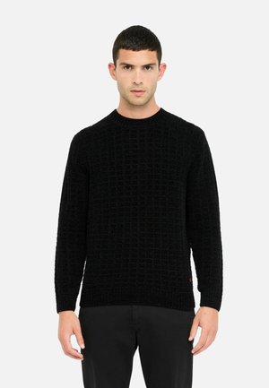 Maglione nero lavorato a maglia con un motivo a griglia testurizzato, scollo rotondo e maniche lunghe. L'orlo e i polsini a coste aggiungono struttura.