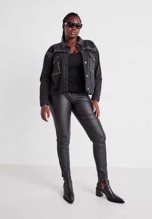 Black denim jacket with studded accents, black tank top, black leather pants, and pointed ankle boots. Sunglasses complete the look.