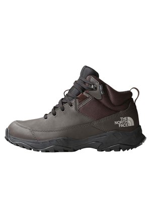 Dark grey and black mid-height hiking boot with textured sole, lace-up front, padded ankle collar, and The North Face logo on the heel.