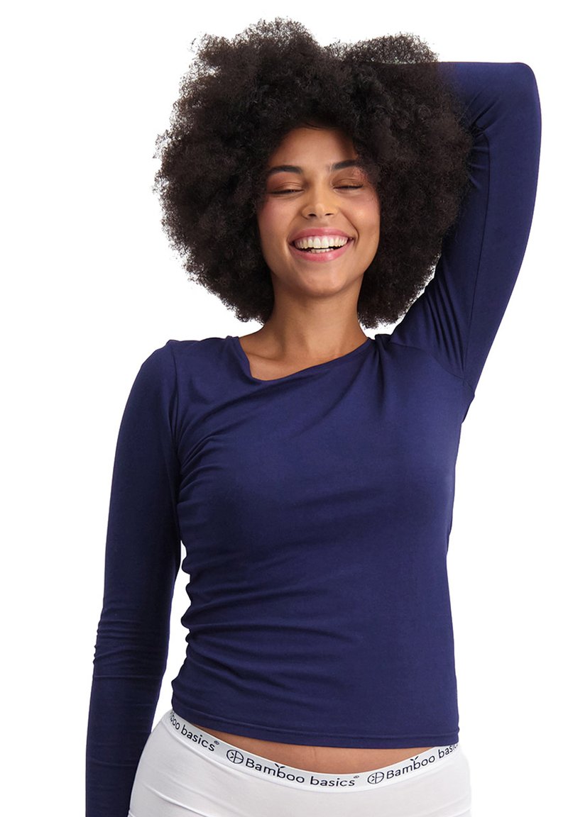 Navy-blaues Langarmoberteil aus weichem Stoff, mit lockerer Passform und seitlicher Raffung, kombiniert mit einem weißen Bund, der mit "Bamboo basics" beschriftet ist.