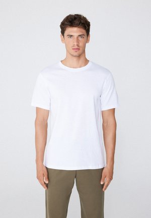 Witte katoenen T-shirt met korte mouwen, ronde hals en een gladde textuur. Gekocht met olijfgroene broek. Eenvoudig, klassiek ontwerp.