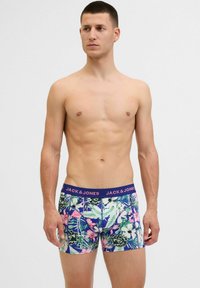 Bunte Boxershorts mit einem tropischen Blumenmuster in Grüntönen, Pink und Lila, versehen mit einem kontrastierenden dunklen Bund, der "JACK & JONES" trägt.