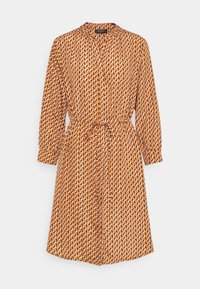 Orange mönstrad klänning med krage, långa ärmar och knytning i midjan. Har en geometrisk design i vitt och svart. Mjuk tygkänsla.