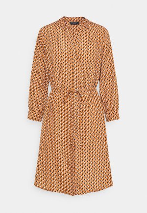Robe à motifs orange avec un col, des manches longues et une taille nouée. Présente un design géométrique en blanc et noir. Texture de tissu douce.
