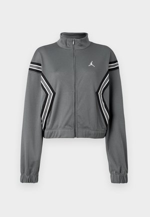 Grijze, korte trainingsjack van gladde stof met een hoge kraag, ritssluiting aan de voorkant en zwart-witte strepen op de mouwen. Heeft een logo op de borst.
