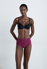 Black padded bra with adjustable straps and a smooth texture. High-waisted maroon briefs with seamless design and elastic waistband.