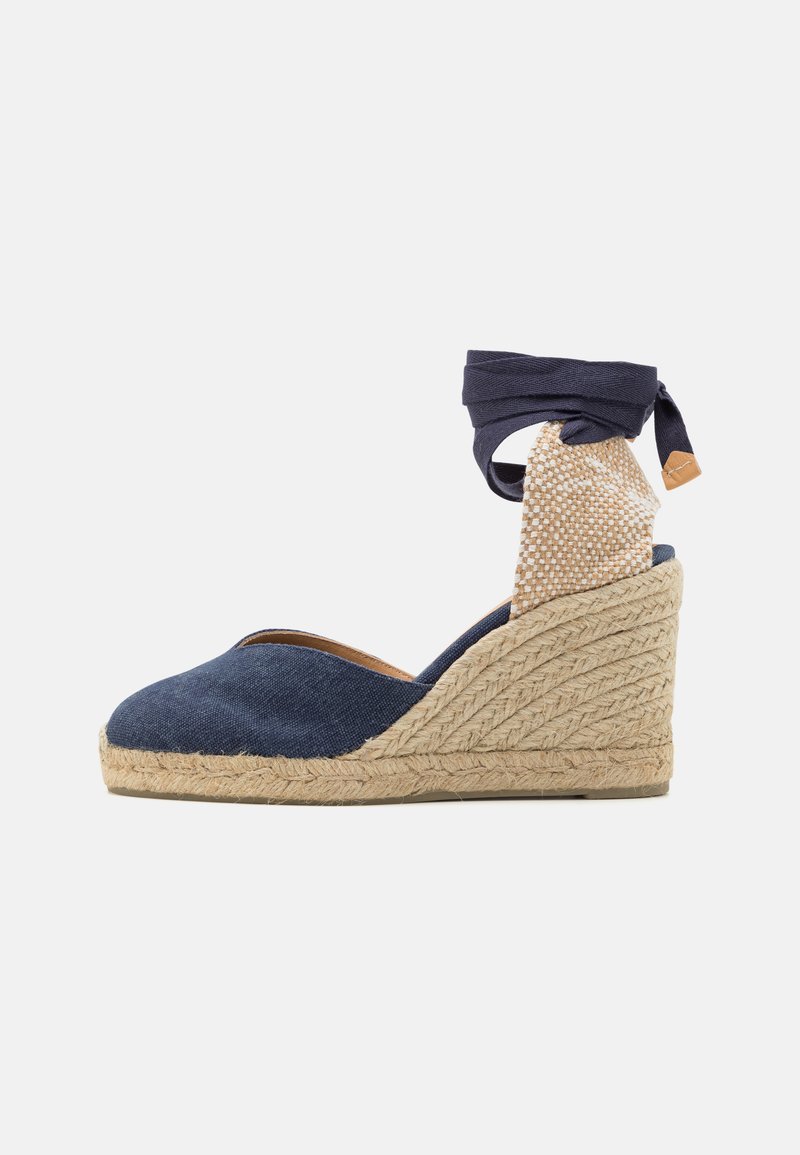 Tengerészkék vászon wedge espadrilles, körbe kötött bokapánttal, juta talppal, és egy texturált bézs panellel a saroknál. Kerek orrú kialakítás.