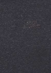 Mörkgrå T-shirt i mjukt tyg, med en liten, färgglad Nike-logotyp på vänster bröst. Texturen är slät med ett svagt melerat mönster.