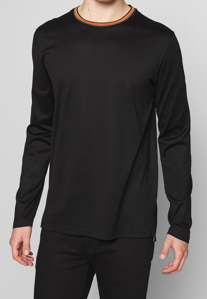 Black long-sleeve t-shirt in soft material with a round neck featuring a colorful ribbed neckline. Fitted design with minimal detailing.