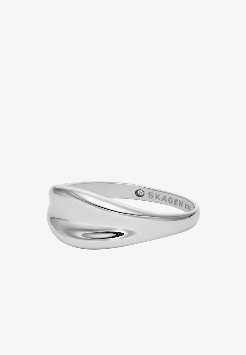Silver-färgad ring med en slät, vågig design. Har en subtil polerad yta och en liten ädelsten som accent nära den inre banden.