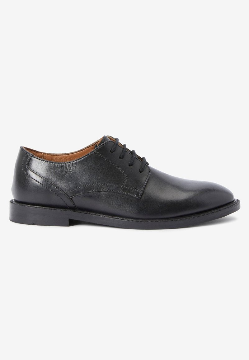 Chaussure habillée noire en cuir pour homme avec lacets, coutures apparentes et petit talon sur fond blanc.