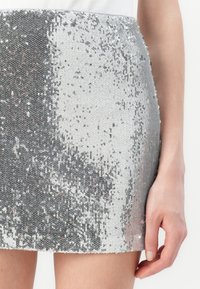 Zilveren pailletten mini rok met een gradient ontwerp, featuring ronde pailletten op een textuurstof, met een glanzend oppervlak en sprankeling.