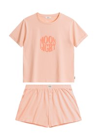 Różowy bawełniany zestaw odzieży domowej, w skład którego wchodzi krótki rękaw T-shirt z nadrukiem "MOON LIGHT" oraz szorty z elastycznym paskiem i detalem w postaci guzika.