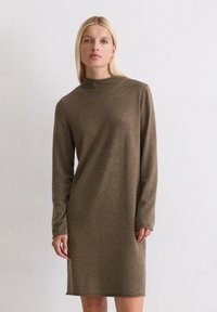 Braunes, langärmliges Kleid mit hohem Kragen; aus weichem Stoff gefertigt; knielanger Schnitt; minimalistische Nähte und keine sichtbaren Muster.