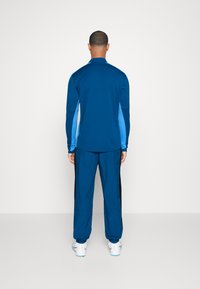 Nike Performance NIKE ACADEMY23 TRACK PANTS - Donji dijelovi trenirke - green abyss/black/baltic blue