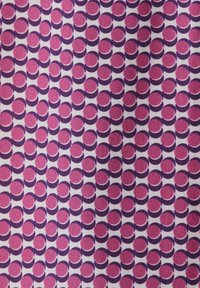 Tessuto con un motivo ripetitivo di cerchi rosa e viola, intervallati da spazi bianchi a contrasto. Il tessuto ha una finitura strutturata.