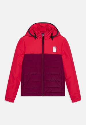 Veste matelassée rouge et violet foncé avec capuche, fermeture éclair complète à l'avant, poignets élastiques et petit logo blanc avec des points rouges sur la poitrine.