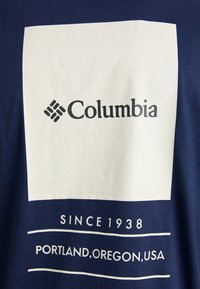 Mørkeblå t-shirt med et stort hvidt firkantet grafisk motiv med "Columbia" logoet, samt teksten "SINCE 1938" og "PORTLAND, OREGON, USA" nedenfor.