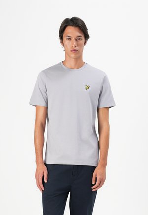 T-shirt en coton gris à manches courtes et col rond, avec un petit logo de papillon jaune sur la poitrine.