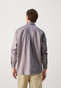 Camicia a maniche lunghe a righe in viola chiaro e crema, con polsini abbottonati e orlo dritto. Tessuto morbido con una vestibilità comoda.
