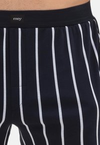 Marine gestreepte boxershorts met witte verticale strepen, gemaakt van zachte stof; voorzien van een comfortabele elastische tailleband en een klein voorkantzakje.