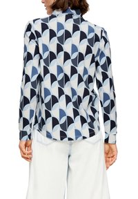 Langärmliges Hemd mit einem geometrischen Muster in verschiedenen Blautönen, Marineblau und Creme. Weicher Stoff mit lockerem Schnitt und abgerundetem Saumdetail.
