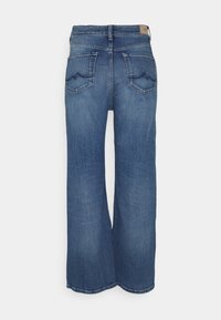 Jeans de denim azul claro con diseño de pierna ancha, cintura de media altura, bolsillos traseros que presentan un patrón de olas y un dobladillo cosido.