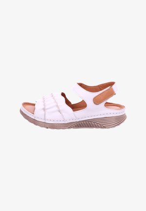White open-toe sandal with adjustable ankle strap, brown cushioned insole, ruched front design, and textured beige sole.