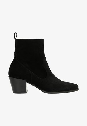 Stivaletto in suede nero con punta affusolata, aperture laterali e tacco a blocco nero texturizzato. Dotato di una linguetta sul retro per un facile indossamento.