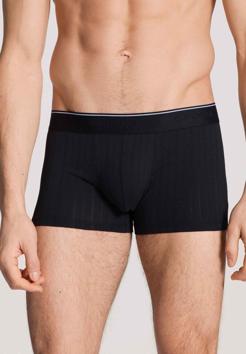 Zwarte geribde boxershorts met een zachte tailleband en een dunne accentstreep, gemaakt van rekbare stof voor comfort.