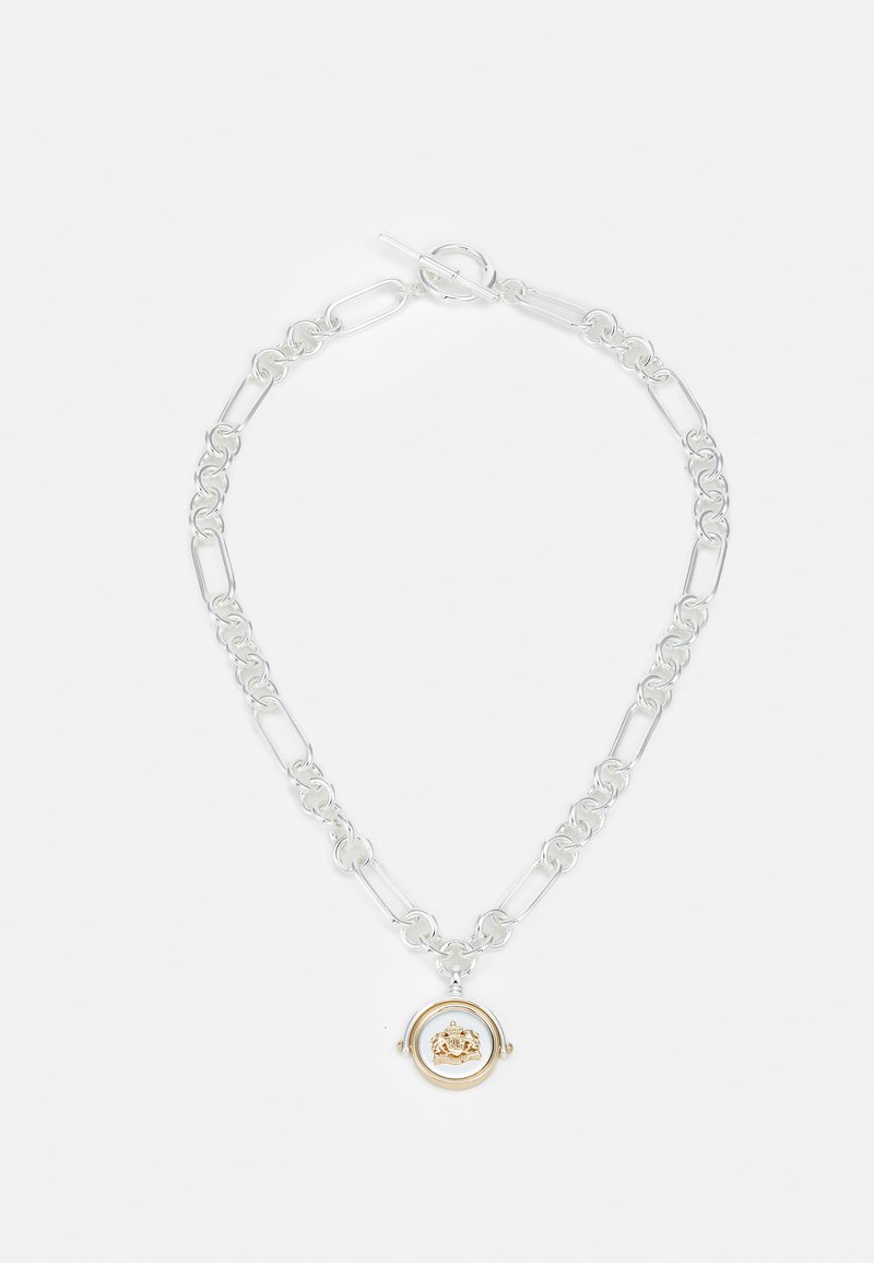 Srebrna verižica z ovalnimi povezavami, z zlatim krožnim obeskom z podrobnim dizajnom v središču in zaponko na preklop.