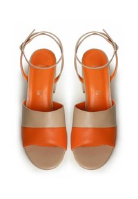 Sandalias de plataforma en naranja y beige con punta abierta, correa en el tobillo y textura de cuero suave; presentan un diseño de bloques de color.