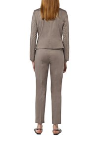 Lichtgrijze op maat gemaakte pak met een slim-fit blazer en slanke broek. Gladde textuur en minimalistisch ontwerp zonder zichtbare patronen of accenten.