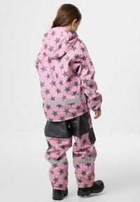 Pink vandtæt jakke og bukser med grå stjernemønstre, der har hætte, elastiske manchetter og reflekterende striber; tekstureret, holdbart materiale.