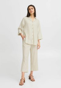 Linnenmix overhemd in lichtbeige met een kraag, knoopsluiting aan de voorkant en driekwartmouwen, gecombineerd met bijpassende wijde broek.