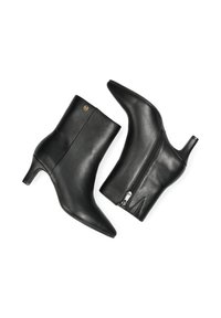 Černé kožené kotníkové boty s špičatou špičkou a 6,5 cm podpatkem, se bočním zipem a zlatým logem jako akcentem. Hladký povrch, elegantní design.