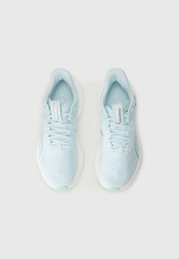 Une paire de chaussures de course légères de couleur bleu clair avec des lacets, des dessus en maille et des semelles blanches, présentée de haut en bas sur un fond blanc.