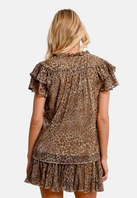 Top con stampa leopardata, maniche a ruffle con strati, tonalità marrone e beige, tessuto testurizzato e dettaglio arricciato sul retro. Design elegante e informale.