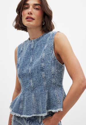 Lichtblauwe denim peplum top met een gestructureerde afwerking. Beschikt over een ronde halslijn en een rafelige zoom. Mouwloos ontwerp met een aansluitende bustehouder.