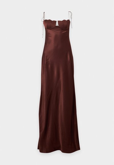 Longue robe en satin brun foncé avec détail festonné à la poitrine et fines bretelles nouées sur un fond uni.
