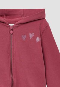 Bordeauxrot zip-up Hoodie mit einem herzförmigen Reißverschlussgriff, der drei glitzernde Herzmuster auf der Vorderseite zeigt. Weicher, strukturiert Stoff.